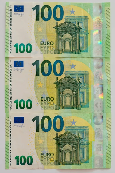 Moneda euro, ofrece billete de banco de 100 euros en moneda europea de mesa blanca — Foto de Stock