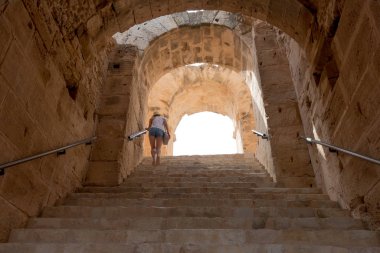 El Jem, Tunus - 22 Temmuz 2018: El Jem, Tunus Amfitiyatrosunda merdivenlerdeki kız