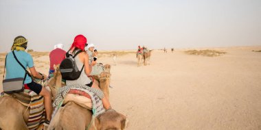 Douz, Tunus - 22 Temmuz 2018: Sahra Çölü, Tunus, Afrika 'da deveye binen bir kız