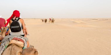 Sahra Çölü 'nde, Tunus' ta, Afrika 'da kum tepelerinde gezen turistler