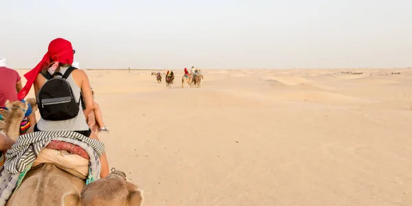 Туристи їдуть верблюдами через піщані дюни пустелі Сахара (Туніс, Африка). — стокове фото