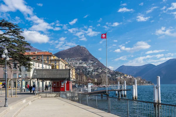 Lugano, İsviçre - 10 Mart 2019: İsviçre bayrağıyla Lugano 'da küçük bir iskele
