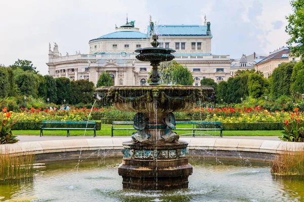 位于维也纳的人民花园（Volksgarten）的喷泉，着眼于奥地利的国家剧院Burgtheater — 图库照片