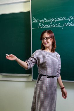Karatahta sınıfındaki öğretmen kadın 14 Şubat 'ta ders çalışmaya başladı.
