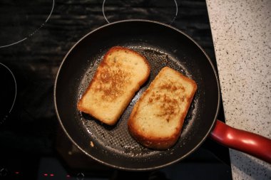 Siyah arka planda tavada kızartılmış beyaz buğday ekmeği.