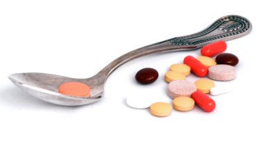 bir çay kaşığı Makro yanındaki hapları yalan