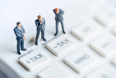 Hesap makinesinin üzerinde duran iş adamları. Hesaplama ve vergi ödemesi. Faiz oranı finansal ve ipotek oranları. Risk yönetimi finansal ve yatırım yüzdesi faiz oranlarının yönetimi.