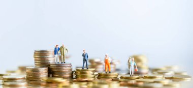 Miniature people standing on stack of coins. Inequality and social class. Income and economic inequality concept. Inequality in social class, ideology, Gender, Racial and ethnic and health.