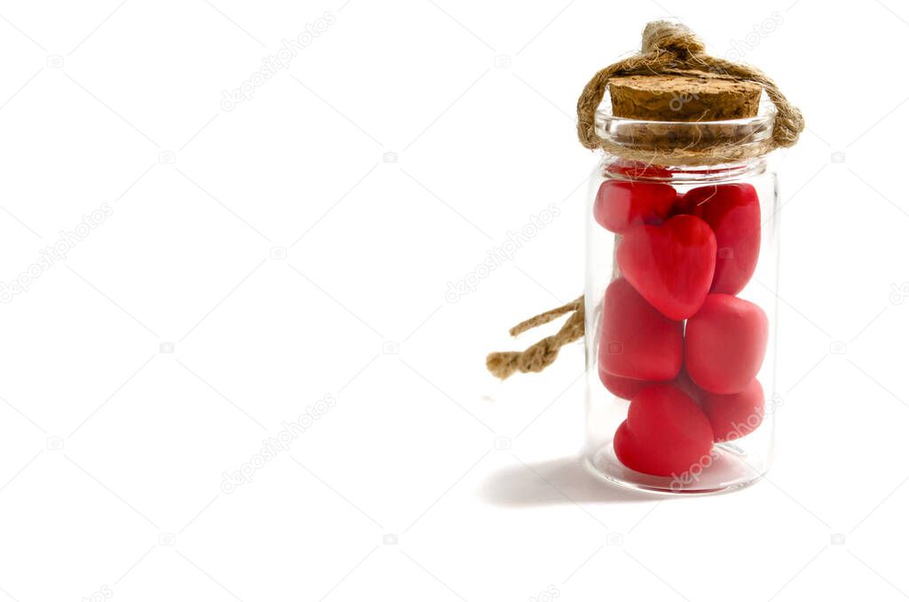 red hearts in a glass bottle with a brown cork and a rope tow on a white background concept valentines day heart thief heartbreaker isolate copyspace