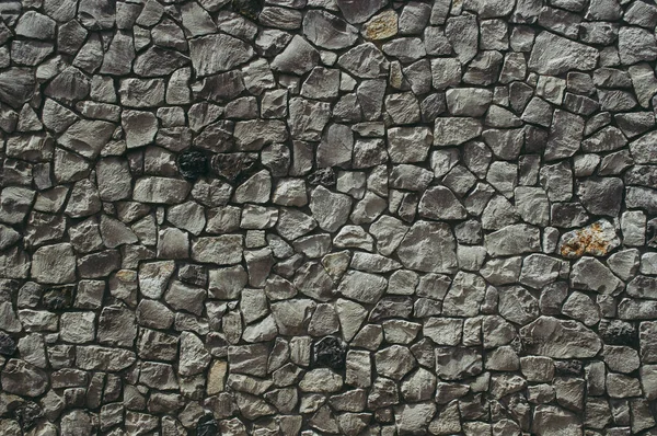 Стена из текстурированных камней темного цвета — стоковое фото