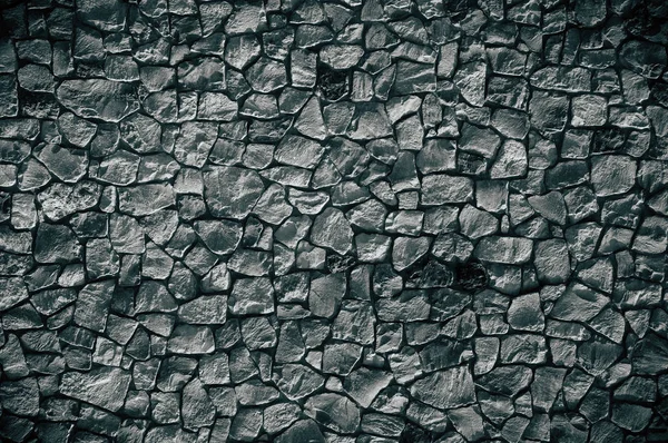 어두운 색깔의 질감있는 돌로 된 벽 — 스톡 사진
