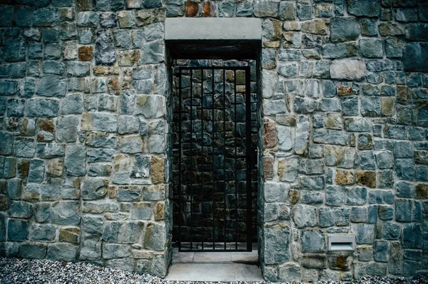 울퉁불퉁 한 암벽 속에 있는 철문 — 스톡 사진