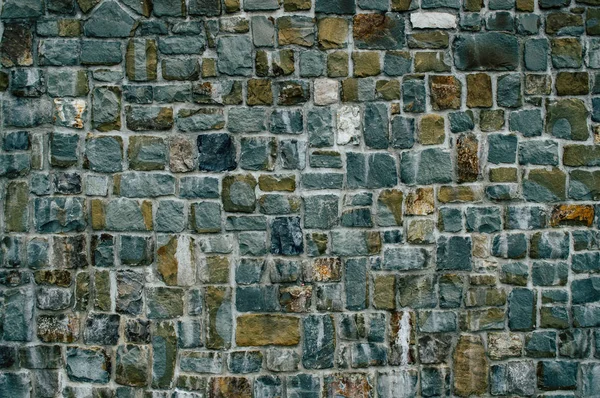 Wand aus strukturierten Steinen in dunklen Farben — Stockfoto