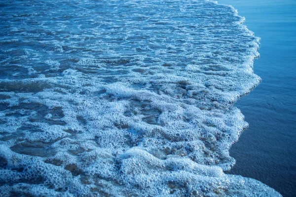 White foam on the surface of the wave comes ashore — ストック写真