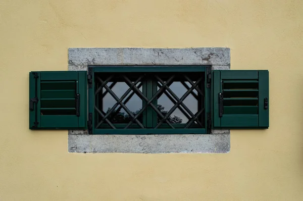 Окно с жалюзи и железные прутья — стоковое фото