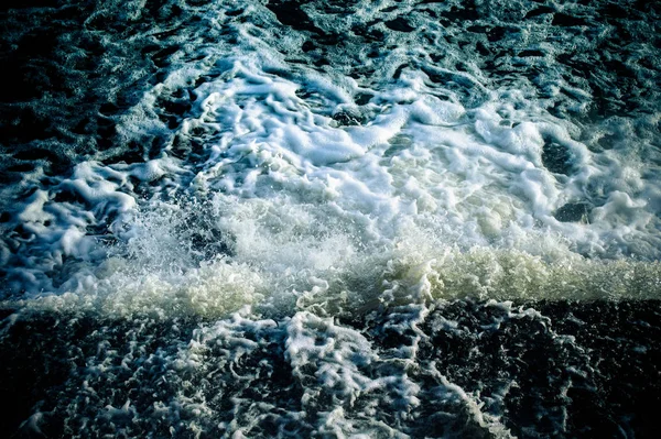 Ένα ρυάκι με νερό χύνεται στο ποτάμι. — Φωτογραφία Αρχείου