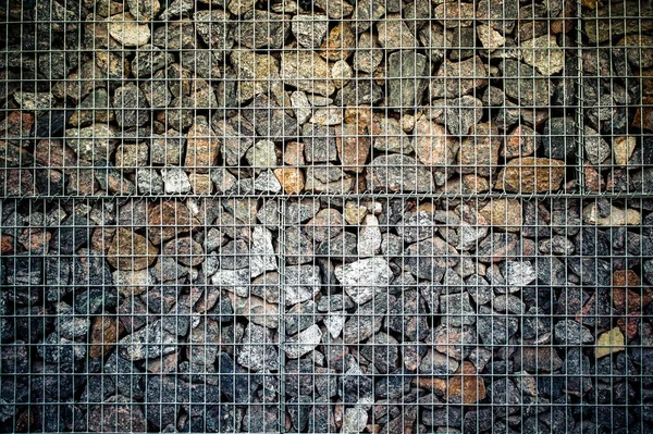 Cerca hecha de piedras en una malla metálica — Foto de Stock