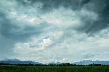 Ufuktaki dağlar gök gürültüsü bulutlarının arka planına karşı kapanıyor.