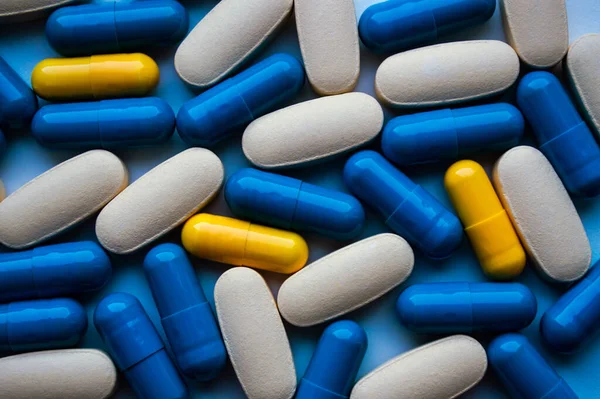 Capsules are scattered on a white surface close up. Medicine concept