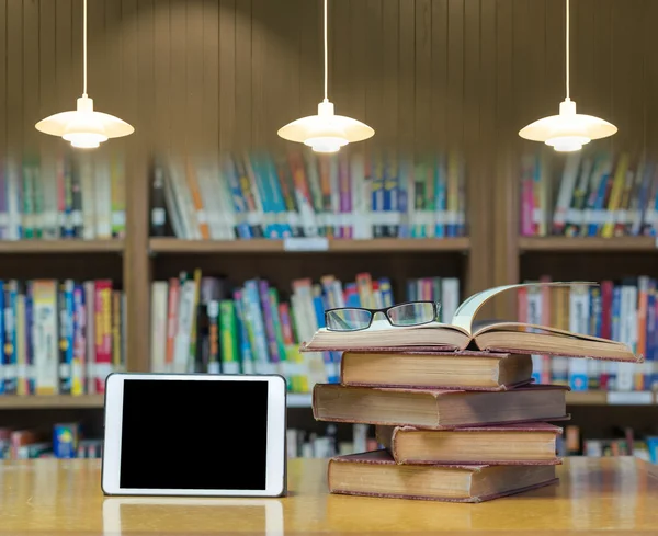 Libros viejos en la biblioteca con la tableta —  Fotos de Stock