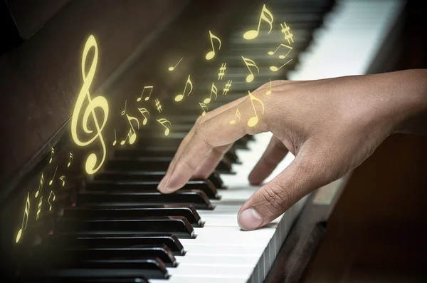 Mão tocando piano com notas de música — Fotografia de Stock