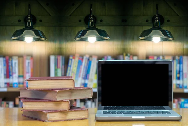 Livros antigos na biblioteca com laptop — Fotografia de Stock