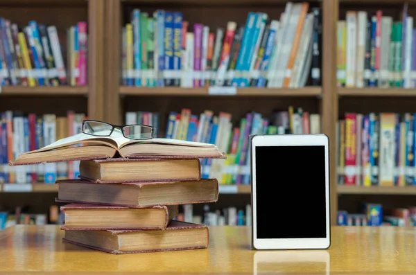 Livros antigos na biblioteca com tablet — Fotografia de Stock