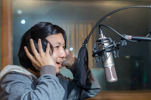 Young Asian singer recording a song