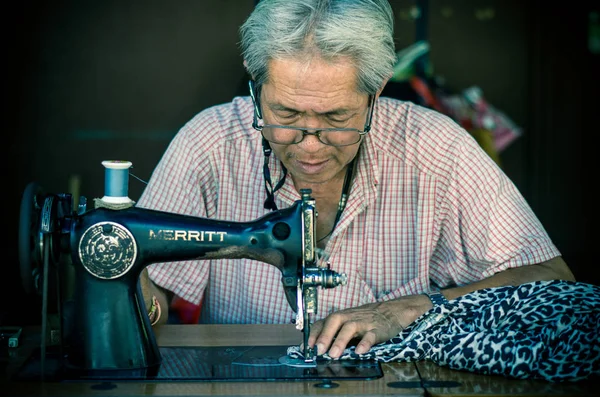 Asian old man Seamstress are sewing — Stock Photo, Image