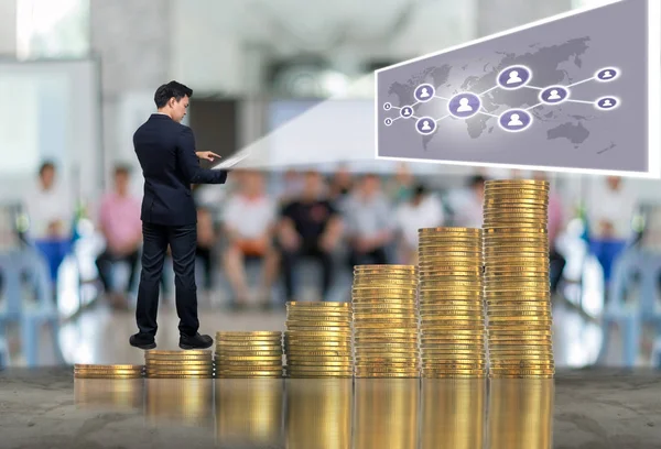Affärsman som stående på högen av mynt — Stockfoto