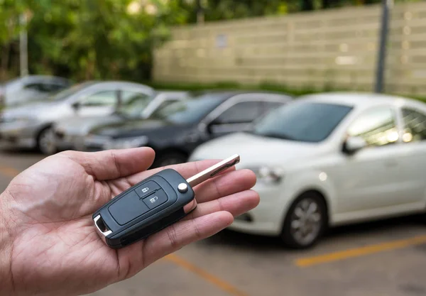 Ruka drží a dává vzdálené klíče od auta — Stock fotografie