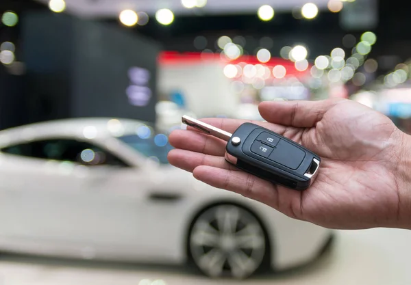 Mano sosteniendo y dando un control remoto de la llave del coche — Foto de Stock