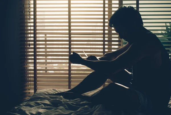 Депресивний чоловік сидить на ліжку — стокове фото