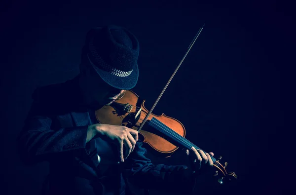 Geigenspieler im dunklen Studio — Stockfoto
