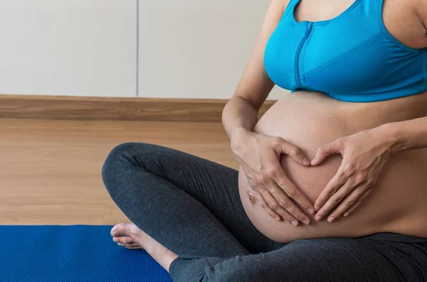 Pregnant female in exercise suit — Stock Photo, Image