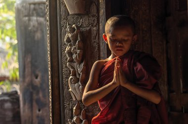 Buddhist novice praying  clipart