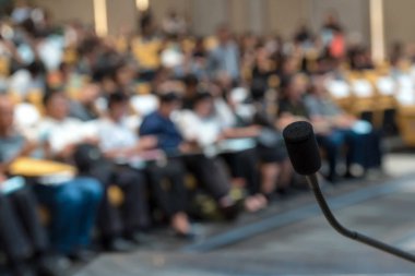 Microphone over blurred conference hall clipart