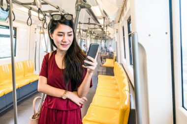 Asyalı kadın yolcu Smartphone kullanarak 