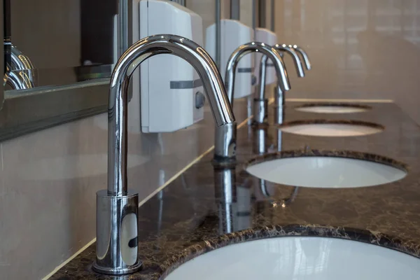 Chrome faucets with washbasins — Stock Photo, Image