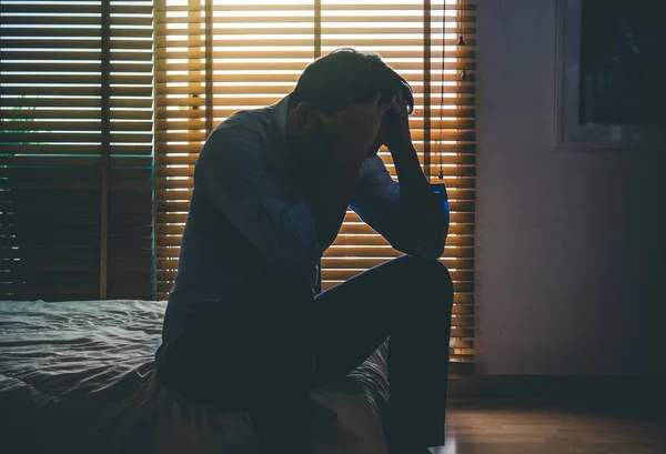 Depressief man zit op bed — Stockfoto