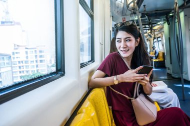 Asyalı kadın yolcu Smartphone kullanarak 