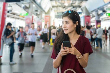 Asyalı kadın yolcu Smartphone kullanarak 