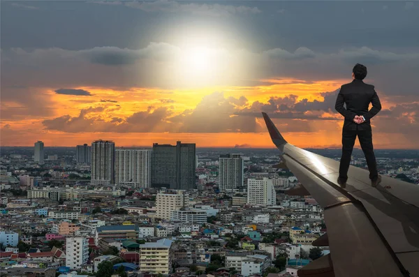 Businessman standing on airplane wing — Stock Photo, Image