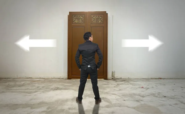 Businessman standing in front of wooden door — Stock Photo, Image