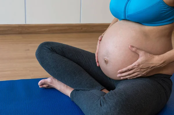 Pregnant woman doing exercises in room — Stock Photo, Image