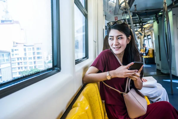Penumpang wanita Asia menggunakan smartphone — Stok Foto