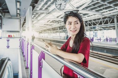 Asyalı kadın yolcu Smartphone kullanarak 