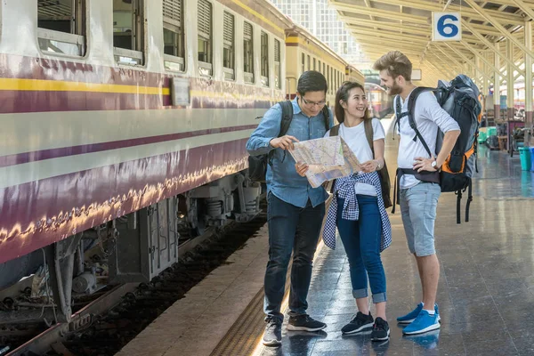 Viajeros multiétnicos mirando el tren —  Fotos de Stock