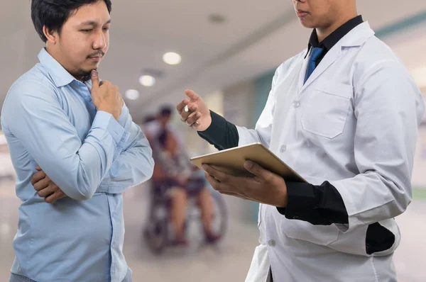 Arzt hält Tablet in der Hand und spricht mit Patient — Stockfoto