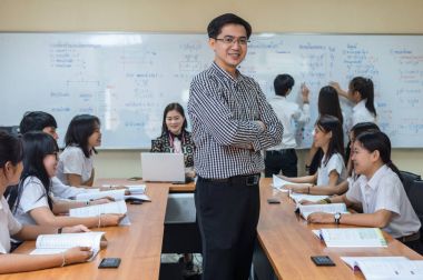 öğretmen öğrencilere vererek ders